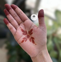 a person's hand with a flower painted on it and a sticker in the palm