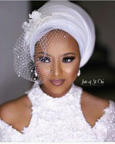 a woman in a white dress with a veil on her head and eyeshade