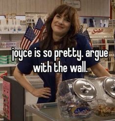 a woman standing behind a counter in a store with an american flag on the wall