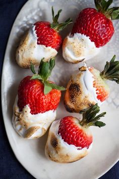 strawberries with cream on them are sitting on a plate