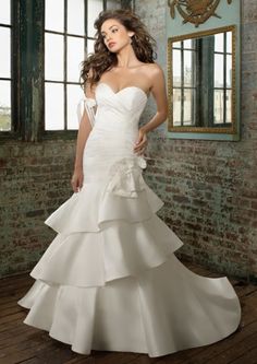 a woman in a white wedding dress posing for the camera