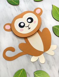 a monkey cut out on top of some green leaves