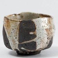 a black and white ceramic bowl on a white surface with small holes in the middle