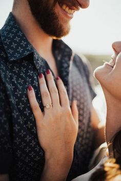 a close up of a woman holding a man's hand and wearing a diamond ring