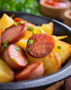 a close up of a plate of food with potatoes and sausages on it's side