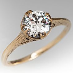 an old - fashioned diamond ring is shown in yellow gold and has a round brilliant center stone