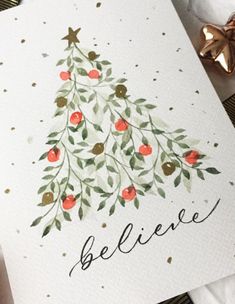 a card with a christmas tree on it and the words believe written in black ink