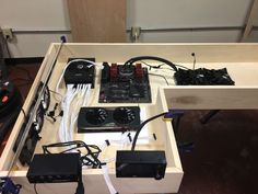 some electronics are sitting on top of a wooden table with wires attached to the sides