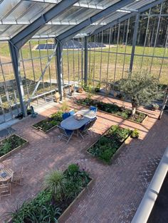 an aerial view of the inside of a greenhouse with tables, chairs and potted plants