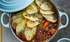 a pot filled with stew and potatoes on top of a table