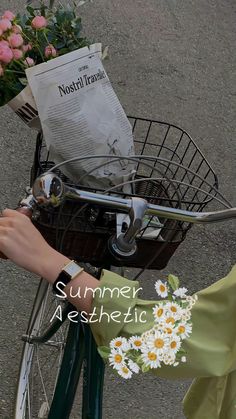 a person riding a bike with flowers in the basket on it's handlebars