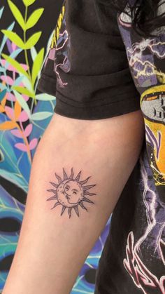 a person with a small sun tattoo on their arm