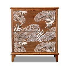 a wooden cabinet with white leaves painted on the front and side panels, along with two drawers