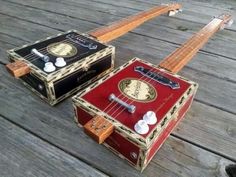 two musical instruments sitting on top of a wooden floor next to each other and one is red