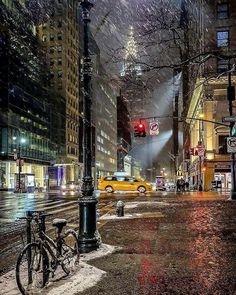 a city street filled with lots of traffic and covered in snow next to tall buildings