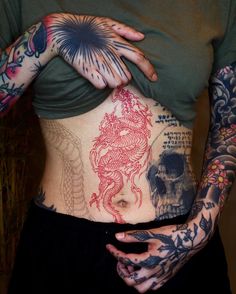 a woman with tattoos on her stomach and arms