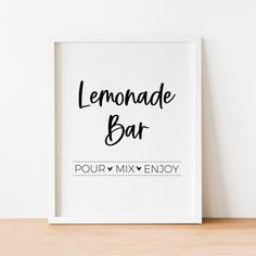 the lemonade bar sign is displayed in front of a white wall and wooden table