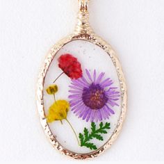 a necklace with flowers in it on a white background