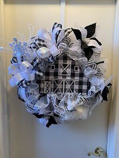 a black and white wreath hanging on the front door