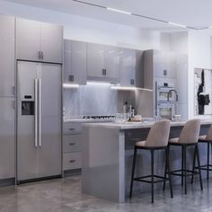 a modern kitchen with stainless steel appliances and marble counter tops, along with bar stools