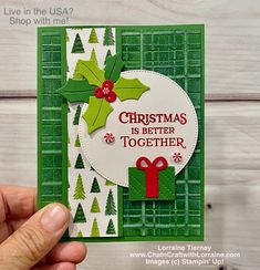 someone is holding up a christmas card with holly and mist on it, which has the words'christmas is better together '