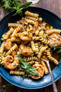 a blue bowl filled with pasta and shrimp