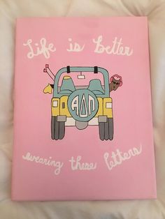 a pink book with an image of a car on the front and writing life is better