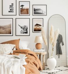 a bed room with a neatly made bed and pictures on the wall