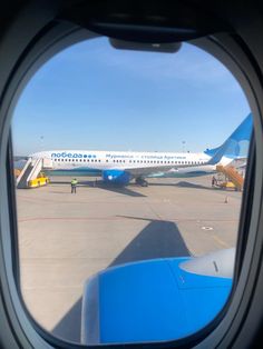 an airplane is seen through the window as it sits on the tarmac