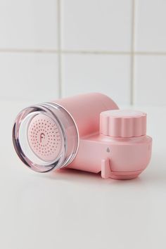 a pink blender sitting on top of a counter next to a white tiled wall