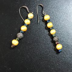 These Beautiful Buttercup Yellow Freshwater Pearl And Iridescent Blue Large Seed Bead Dangle Earrings Feature 6-8 Mm Almost Round Natural Fresh Water Pearls. It Also Has A Pewter Rose Focal Accent Finding Near The Bottom. Nickel-free Yellow Dangle Beaded Earrings, Nickel Free Yellow Dangle Beaded Earrings, Yellow Beaded Earrings In Czech Glass, Yellow Beaded Earrings With Czech Glass, Handmade Yellow Beaded Earrings With Czech Glass, Yellow Czech Glass Beaded Dangle Earrings, Yellow Beaded Czech Glass Earrings, Yellow Czech Glass Round Bead Earrings, Yellow Czech Glass Dangle Earrings