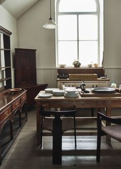 a dining room table with plates and bowls on it