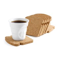 a cup of coffee sits next to some slices of bread