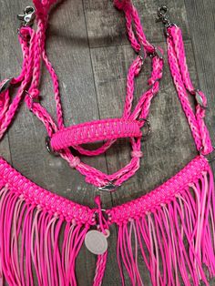 a pink roped halter and reins on a wooden floor