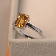 This ring features a 6*8mm emerald cut natural citrine and sterling silver finished with rhodium. Customization is available. It is made by hand, and it will take about 7 days to finish the ring after your payment is completed. Main stone: natural citrine Main stone weight: Approx 1.56 ct Metal type: sterling silver finished with rhodium Customization is available, I also can make it with 14k solid gold (white or yellow or rose) and diamond accent stone, just feel free to contact me. Any questio Citrine Wedding Ring, Yellow Topaz Ring, Yellow Gemstone Ring, Emerald Cut Solitaire Ring, Citrine Engagement Ring, Citrine Wedding, Yellow Citrine Ring, Citrine Ring Engagement, Mystic Topaz Ring