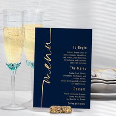 two glasses of champagne next to a menu