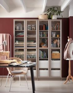 a room with a table, chair and bookcase full of books on it's shelves