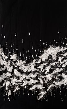 an embroidered black and white cloth with silver sequins