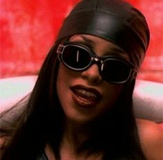 a woman wearing sunglasses and a leather hat