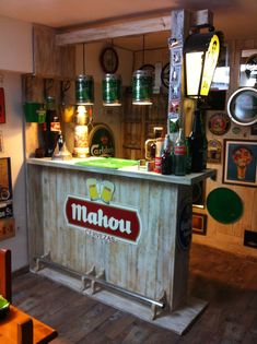 a small bar with many different types of beer on display in a room filled with other items