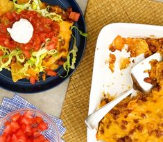 two plates of food on a table with utensils and napkins next to them