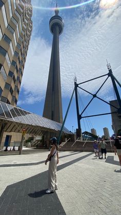 a woman standing in front of a tall building with a sky scraper behind her