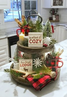 three tiered tray with christmas decorations and candles on the counter top in a kitchen