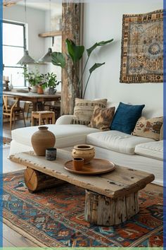 a living room with white couches and wooden table in the middle, surrounded by potted plants