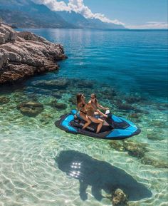 two women on a blue jet ski in clear water