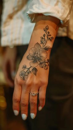 a woman's hand with a flower tattoo on it