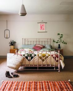 a bedroom with a bed, rugs and shoes on the floor in front of it