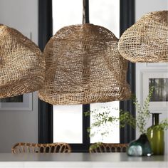 three woven lamps hanging from the ceiling in a kitchen