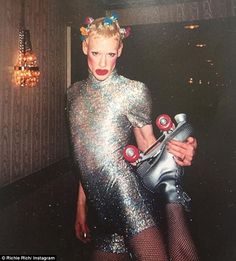 a woman dressed in silver holding a skateboard