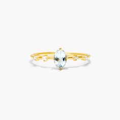 a yellow gold ring with an aqua blue topazte and three white diamonds on it